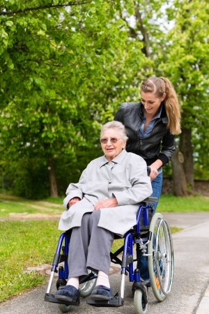 14727941 - young woman is visiting her grandmother in nursing home having a walk with here in a wheelchair